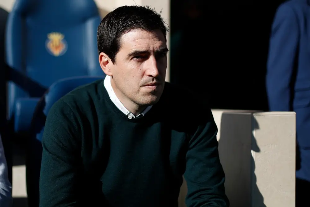 Andoni Iraola smiling on the touchline during a Premier League match