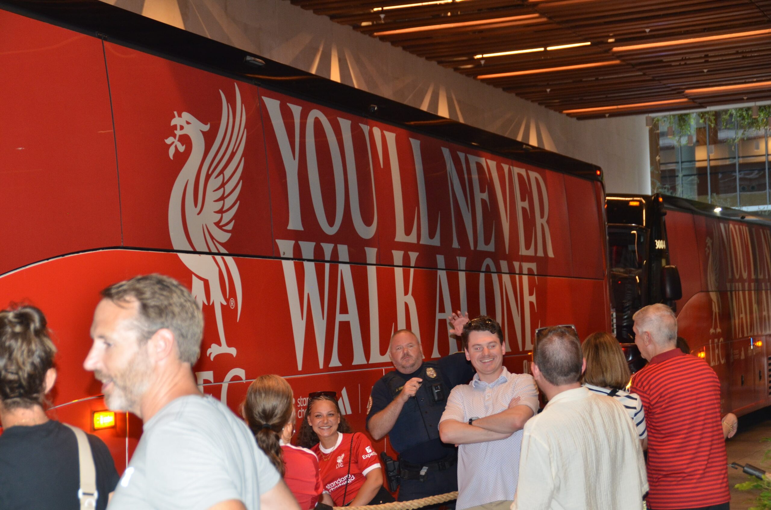 The official Liverpool FC team bus displaying You'll Never Walk Alone arriving in Nashville